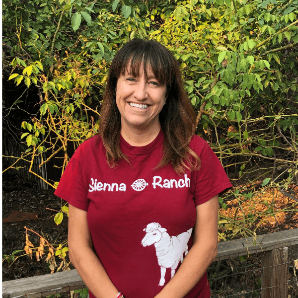 A woman wearing a t - shirt that says jenna ranch.