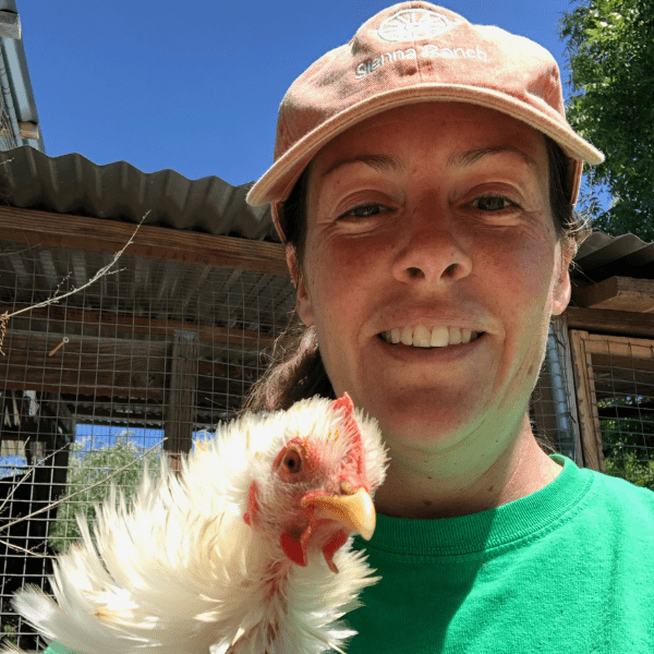 A woman holding a chicken in her hand.