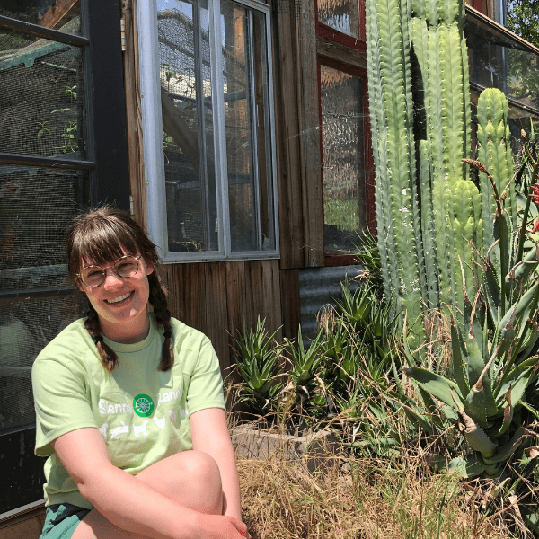 A woman sitting in front of some cactus